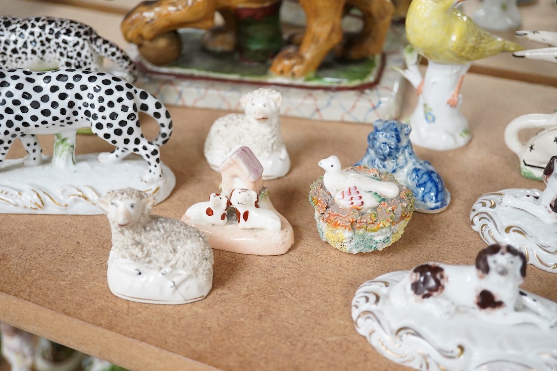 A collection of 19th/20th century Staffordshire and continental porcelain models of animals and birds, including a 20th century Meissen figure of a canary, two Continental porcelain Panthers, two similar recumbent dogs,